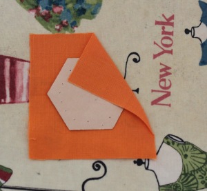 Dab a little glue on paper and attach to the fabric. Do not trim into a hexagon shape. Press.